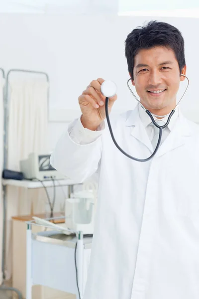 Médico Segurando Pedaço Prata Estetoscópio Frente Dele Enquanto Sorri — Fotografia de Stock