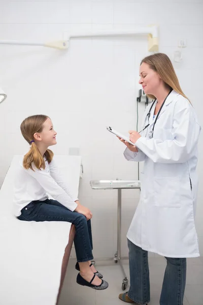 Smiling Doctor Talking Smiling Girl Sitting Table Examination Room — Stock Photo, Image