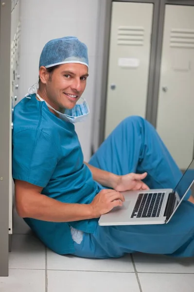 Chirurg Siedzący Podłodze Szafki Podczas Korzystania Laptopa Szpitalu — Zdjęcie stockowe