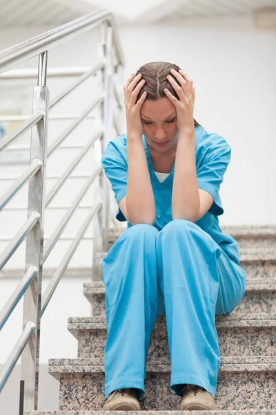 Nurse Holding Her Head Her Two Hands Stairs Hospital — Stock Photo, Image