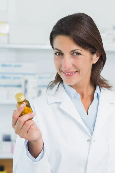 Uśmiechnięta Farmaceutka Trzymająca Butelkę Tabletek Aptece Szpitalu — Zdjęcie stockowe