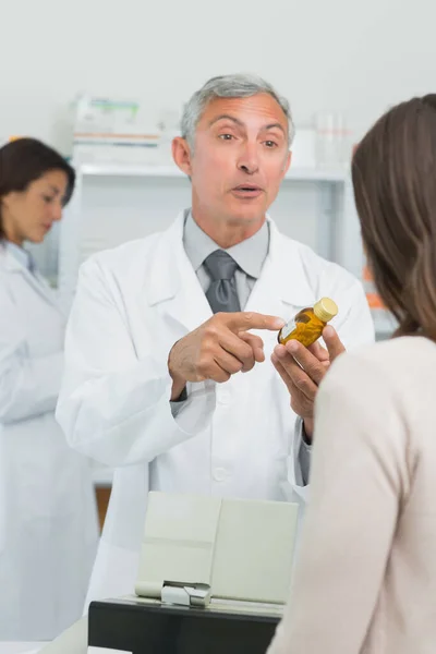 Фармацевт Клиентом Указывающим Фляжку Таблетками Аптеке — стоковое фото