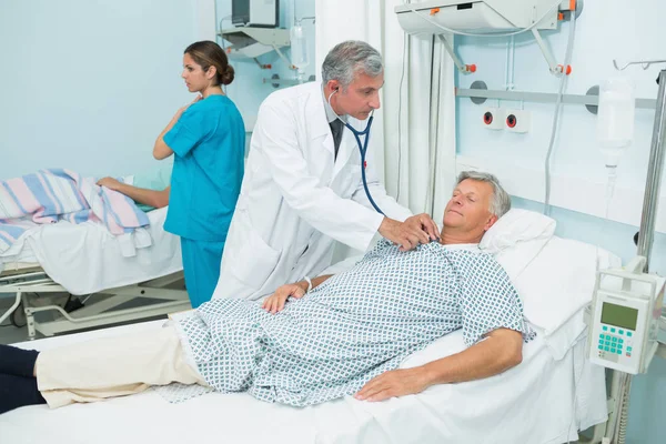 Médico Masculino Auscultando Paciente Masculino Una Sala Cama Hospital — Foto de Stock