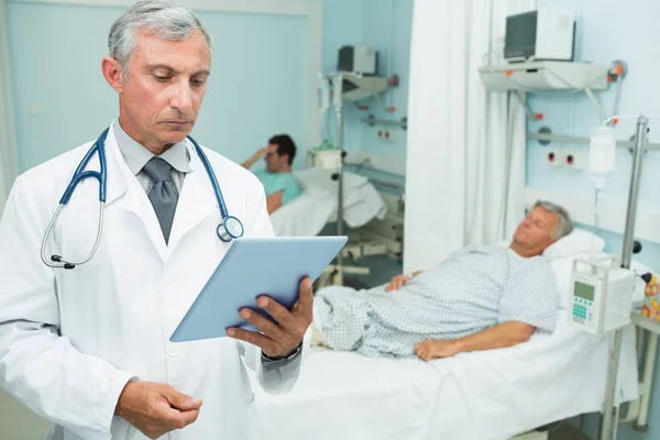 Doctor Con Una Tableta Táctil Mientras Encuentra Una Cama Hospital — Foto de Stock