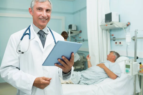 Šťastný Lékař Drží Hmatovou Tabletu Zatímco Stojí Nemocnici — Stock fotografie