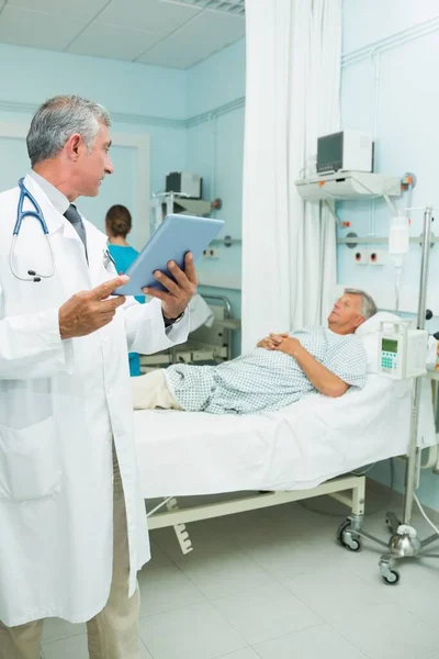 Médico Serio Que Usa Una Tableta Táctil Mientras Mira Paciente — Foto de Stock