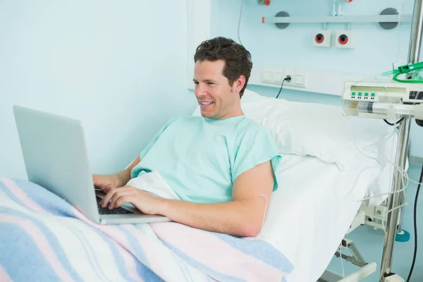 Радісний Пацієнт Друкує Ноутбуці Лежачи Лікарняному Ліжку — стокове фото