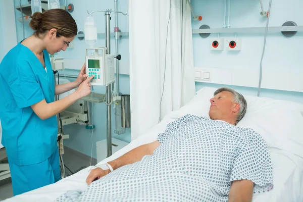 Enfermera Revisando Una Máquina Médica Junto Paciente Acostado Una Cama — Foto de Stock