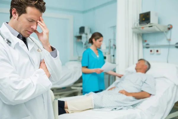 Nachdenklicher Arzt Mit Standing Vordergrund Eines Krankenhauszimmers — Stockfoto
