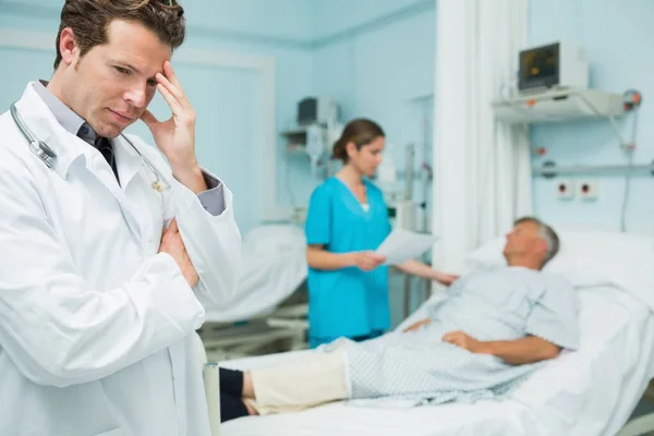 Denkender Arzt Der Vordergrund Eines Krankenhauszimmers Steht — Stockfoto