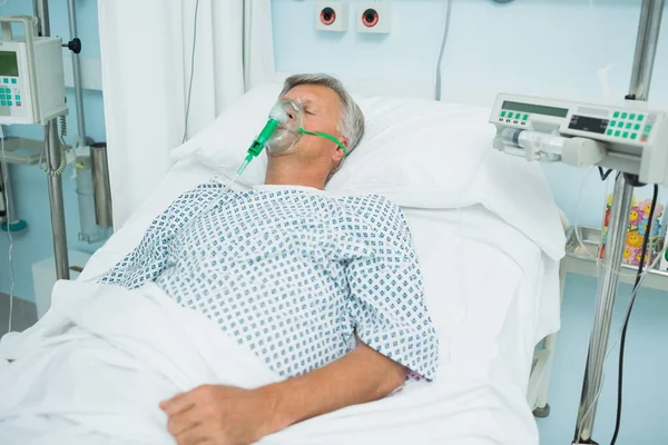 在医院里躺在床上戴氧气面罩的不省人事病人 — 图库照片