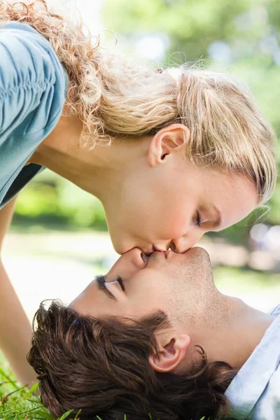 一对情侣在草坪上接吻的侧影 — 图库照片