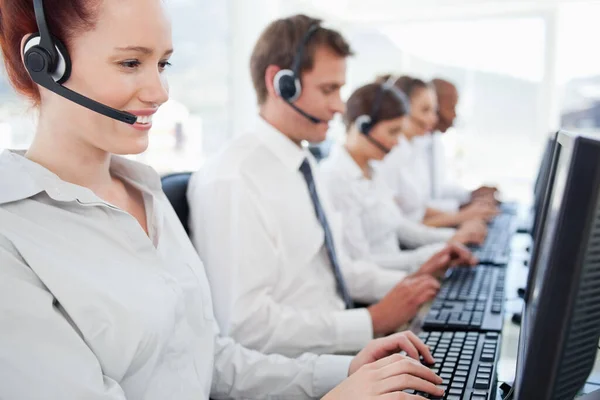 Call center agents sitting in a line at work