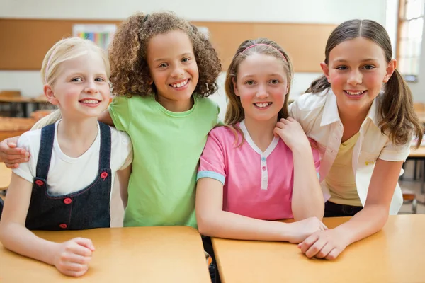 Leende Skolflickor Tillsammans Bakom Skrivbordet — Stockfoto