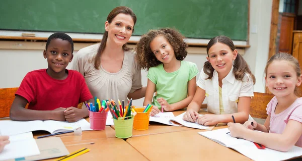 Smiling teacher with her students during art class