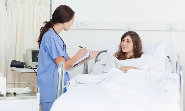 护士拿着记事板和病人讨论时 — 图库照片