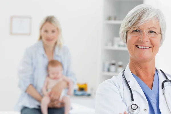 Glimlachen Volwassen Arts Met Vrouw Haar Baby Achter Haar — Stockfoto