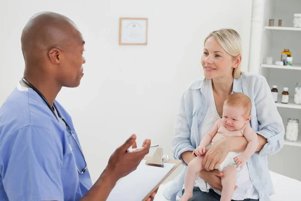Doctor Hablando Con Madre Bebé Paciente —  Fotos de Stock