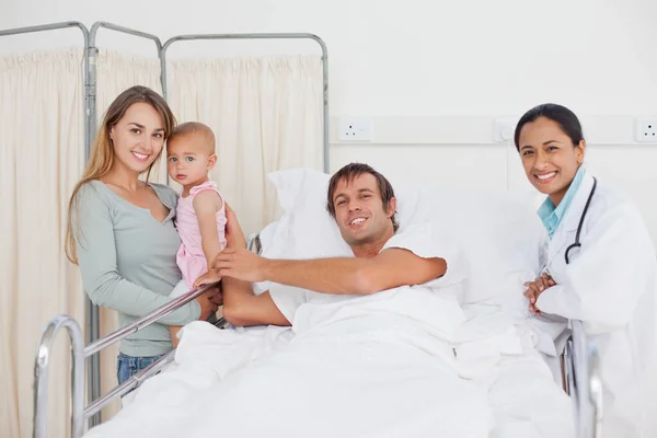 Усміхнений Пацієнт Лежить Лікарняному Ліжку Оточений Його Сім — стокове фото