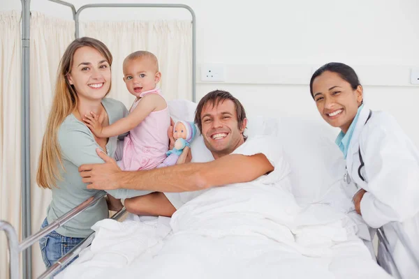 Lächelnde Familie Umarmt Sich Einem Krankenhauszimmer Während Ein Arzt Neben — Stockfoto