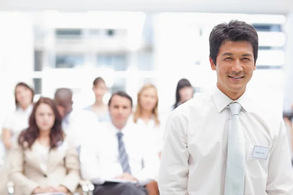 Empresario Sonriendo Mientras Para Frente Sus Colegas —  Fotos de Stock