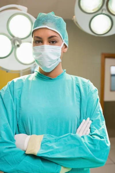 Serious nurse with arms crossed looking at camera in an operating theatre