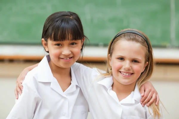 快乐的小女孩穿着校服站在黑板前 — 图库照片