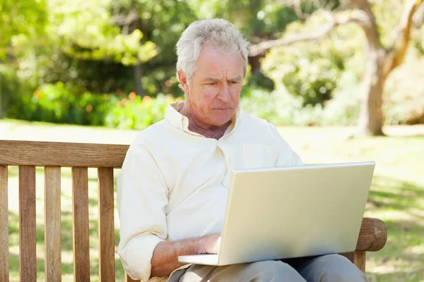 Uomo Che Utilizza Computer Portatile Mentre Seduto Una Panchina — Foto Stock