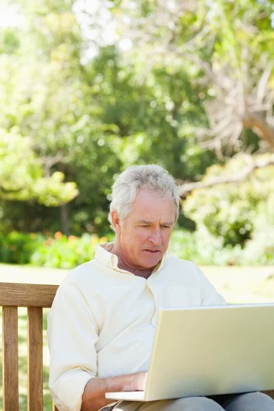 Homem Olhando Para Algo Laptop Enquanto Sentado Banco — Fotografia de Stock
