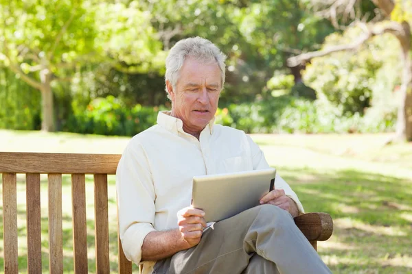 Man Die Naar Een Tablet Kijkt Terwijl Hij Een Bank — Stockfoto