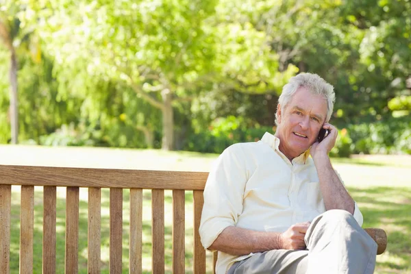 Man Smiling Looking Ahead Makes Call While Sitting Bench — Stock Photo, Image