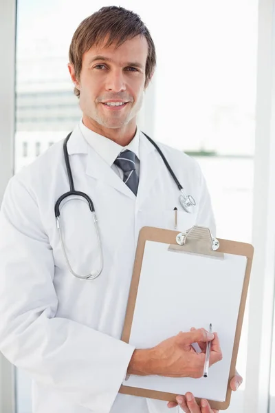 Médico Sonriente Que Señala Portafolio Con Una Pluma Puntos Votación — Foto de Stock