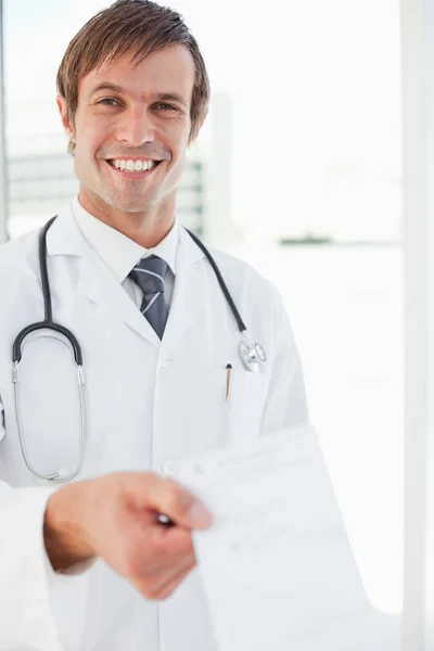 Cirurgião Sorrindo Segurando Uma Prescrição Frente Uma Janela — Fotografia de Stock