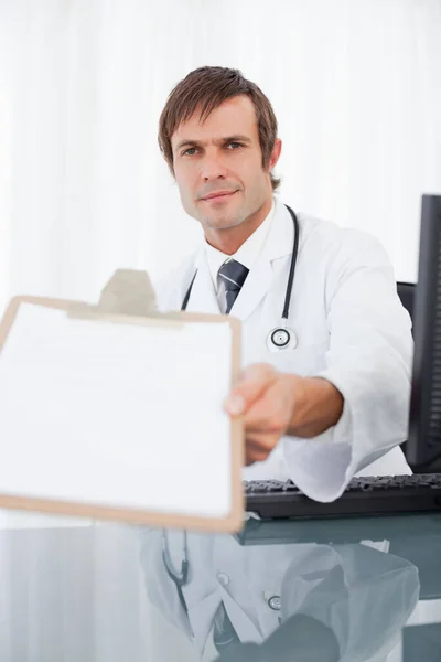 Médico Segurando Uma Área Transferência Enquanto Sentado Mesa — Fotografia de Stock