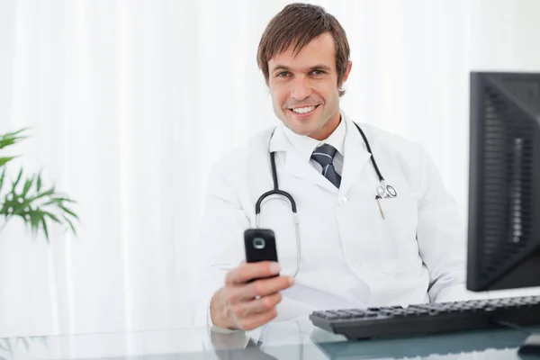 Smiling Doctor Sending Text While Sitting Desk —  Fotos de Stock