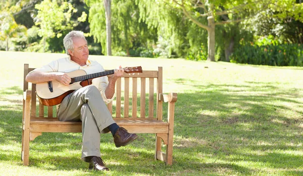 Man Playing Guitar Sits His Legs Crossed Royalty Free Stock Images