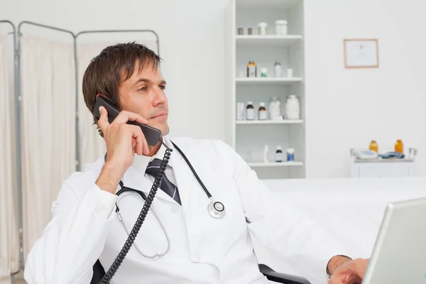 Allvarlig Läkare Tittar Bort Medan Talar Telefon — Stockfoto