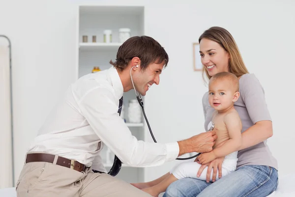 Lachende Moeder Die Haar Baby Vasthoudt Terwijl Dokter Haar Hartslag — Stockfoto