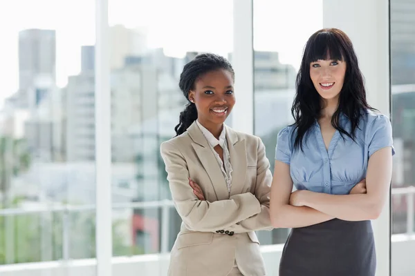 Two Smiling Businesswomen Standing Well Lit Room Arms Crossed — Stock Photo, Image