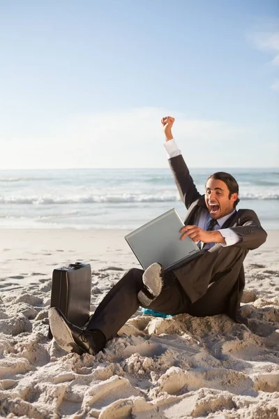 Affärsman Lyfta Ett Ben Och Arm När Sitter Stranden — Stockfoto