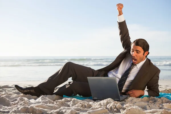 快乐的生意人一边躺在沙滩上一边 一边举手投足 取得了成功 — 图库照片