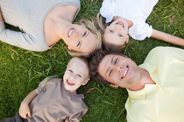 一个微笑的家庭一起躺在地上 — 图库照片