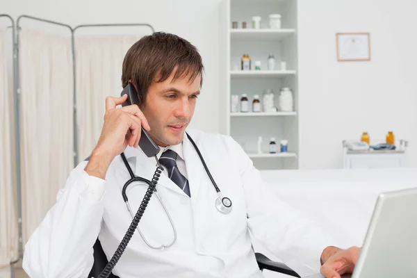 Serious Doctor Using His Laptop While Talking His Phone — Stock Photo, Image