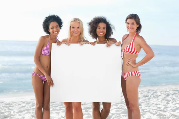 Four Women Smiling Hold Large White Poster — Stock Photo, Image