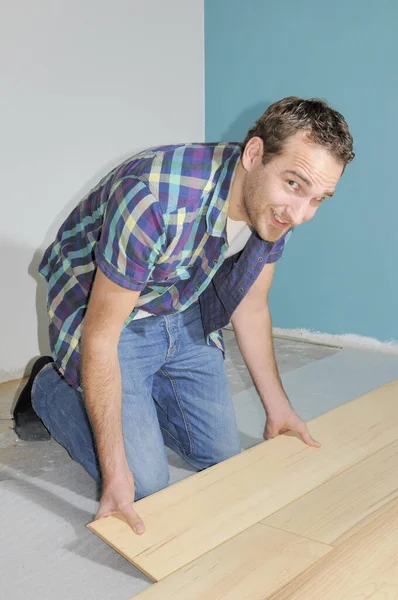 Człowiek Instalowanie Drewnianej Podłogi Meblami — Zdjęcie stockowe