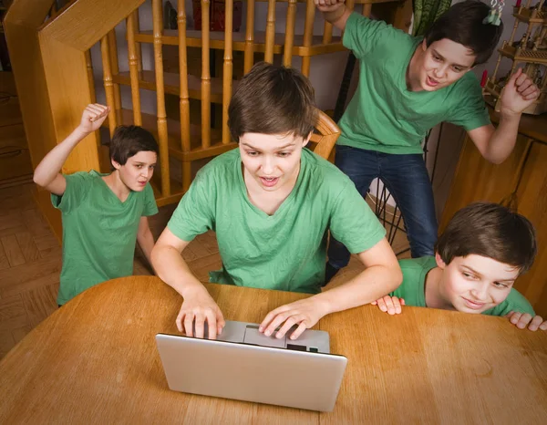 緑のTシャツに身を包んだ10代の男の子がノートパソコンを持ち様々なポーズで — ストック写真