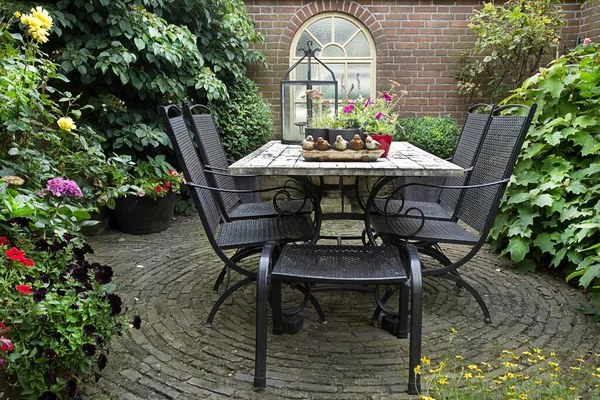 夏の花 テーブルの装飾や植物と庭の鉄鍛造テーブルと椅子 — ストック写真