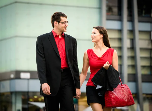 仕事の後若い笑顔のビジネスカップルが通りを歩く — ストック写真