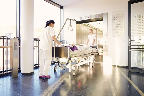 nurses with bed and patient in hospital