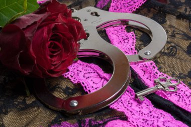 a pair of handcuffs with a red rose for the lady clipart